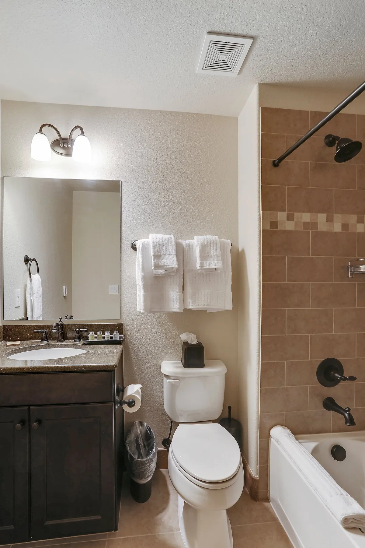 A spotless bathroom featuring a modern vanity with a large mirror, a spacious glass-enclosed shower, and fresh towels on a rack. The design is inviting and functional, ideal for personal grooming and relaxing baths.