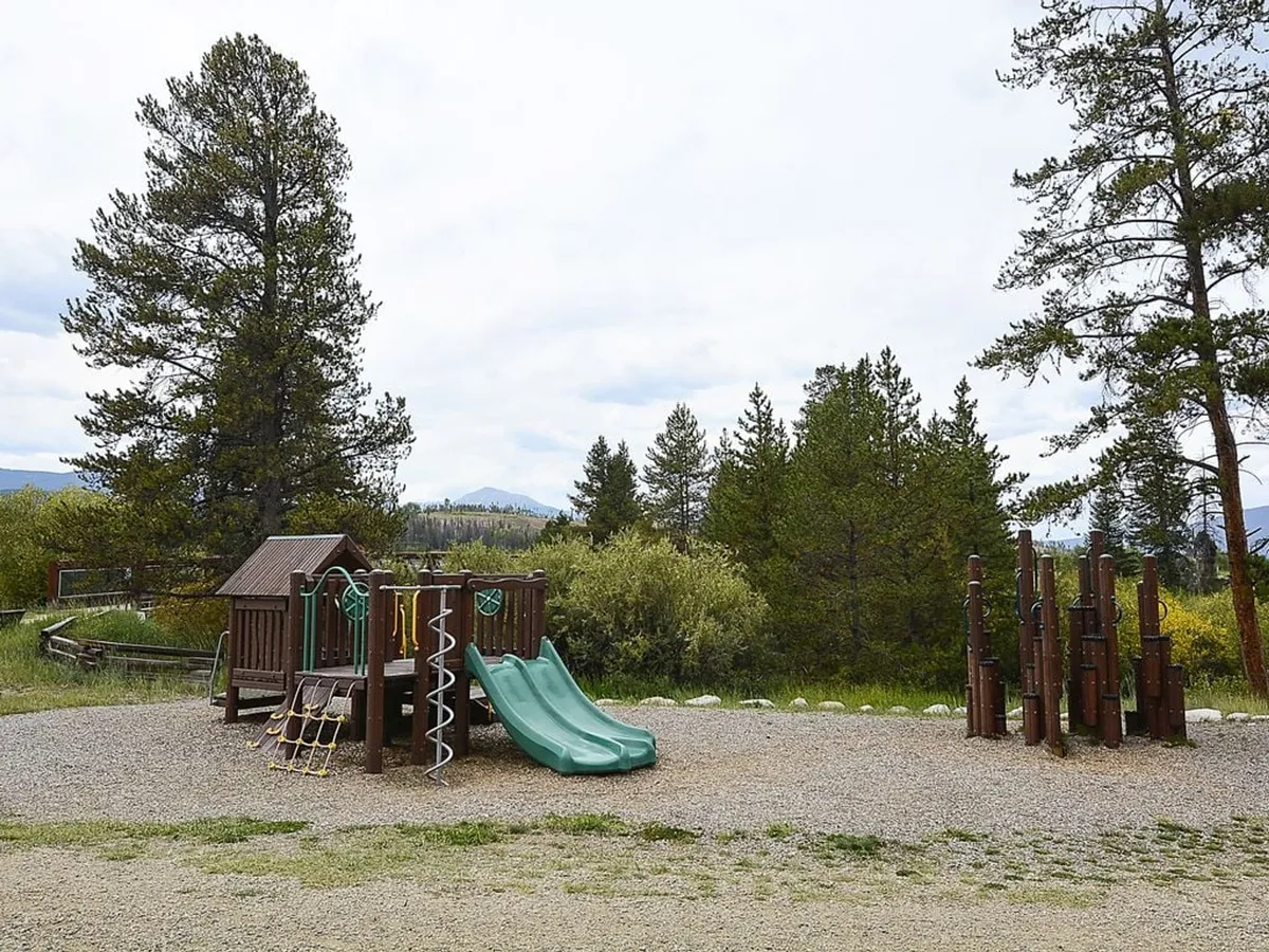 An inviting playground with slides and climbing structures, set in a landscaped outdoor environment suitable for family gatherings and children’s activities.