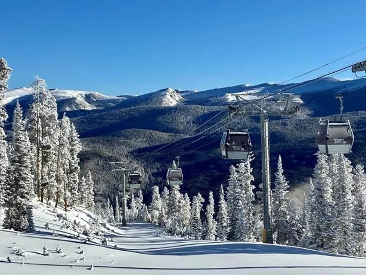 A panoramic outdoor scene featuring ski lift gondolas gliding over snow-covered trees, with expansive mountain landscapes in the background. The setting feels both adventurous and peaceful, hinting at outdoor leisure and winter excitement.